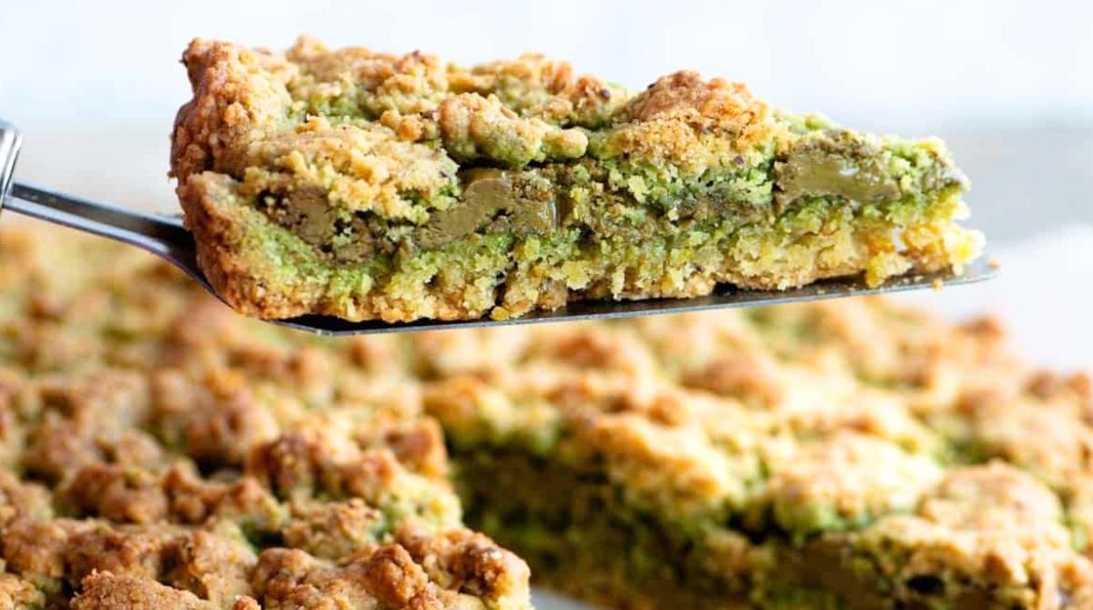 Questa sbrisolona al pistacchio sembra rustica, ma il cuore cremoso la trasforma in un dolce “da bar di lusso”: croccante fuori, fondente dentro